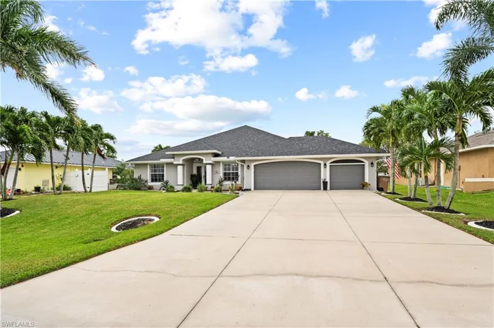 Ranch-style home featuring a front lawn and a garage