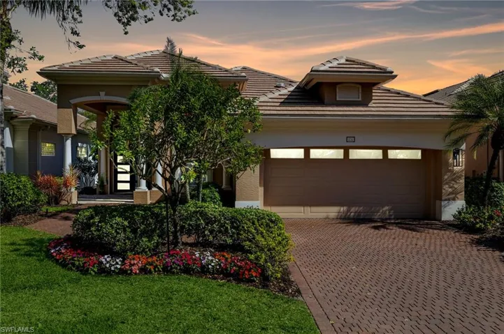 View of front of house featuring a garage, a tiled roof, decorative driveway, and stucco siding