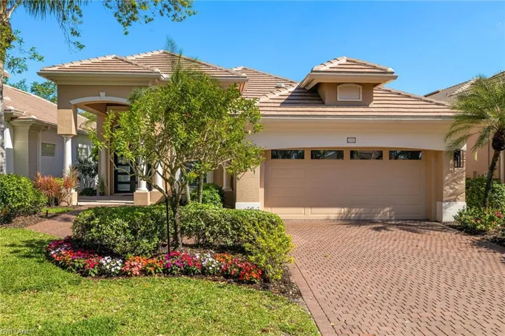 View of front of property with an attached garage, a tile roof, decorative driveway, and stucco siding