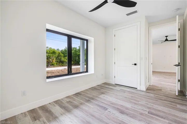 Unfurnished bedroom featuring baseboards, visible vents, light wood-style floors, and a ceiling fan
