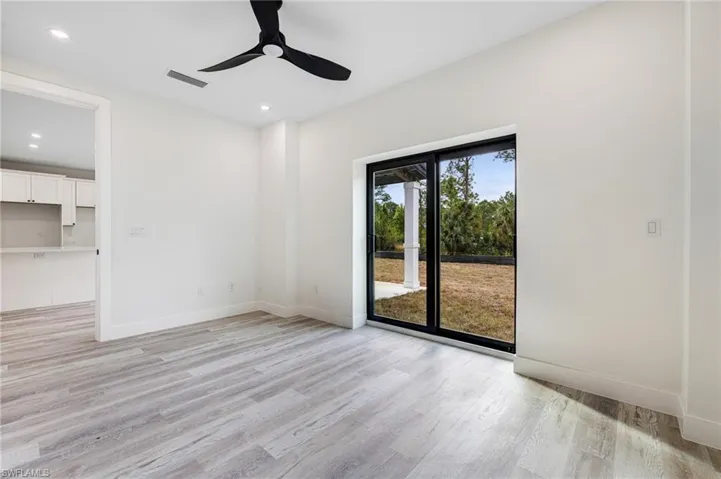 Unfurnished room with baseboards, light wood-type flooring, and a ceiling fan