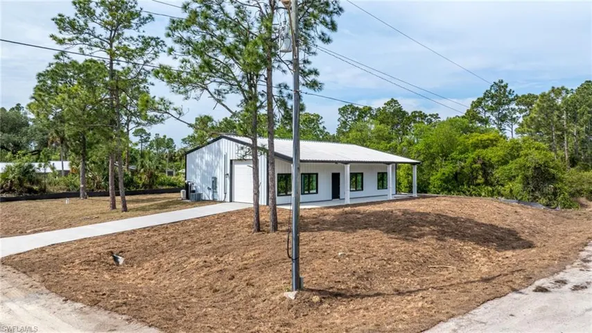 View of front of property featuring concrete driveway, a garage, and central air condition unit
