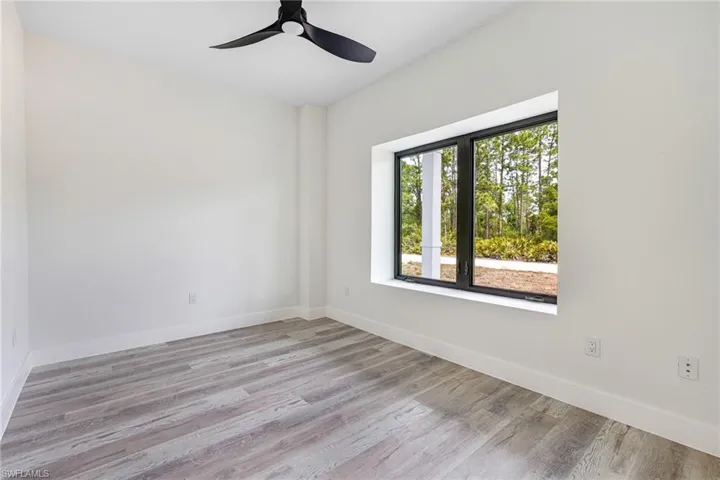 Spare room with baseboards, wood finished floors, and ceiling fan