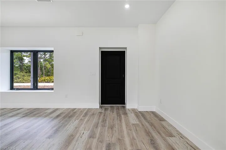 Spare room featuring light wood-style flooring, baseboards, and recessed lighting