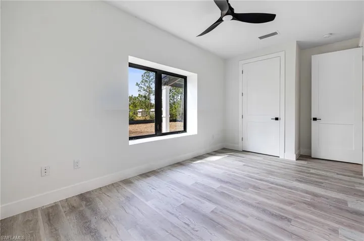 Unfurnished bedroom featuring baseboards, light wood-type flooring, visible vents, and a ceiling fan