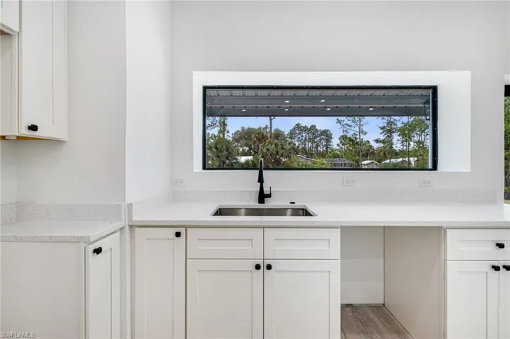 Kitchen featuring white cabinetry, a sink, and light wood finished floors