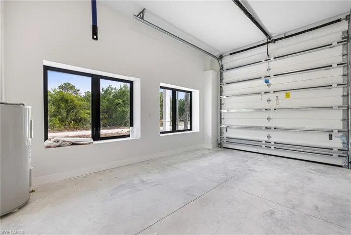 Garage with baseboards and fridge
