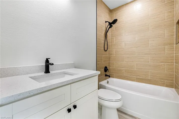 Bathroom featuring tub / shower combination, toilet, and vanity
