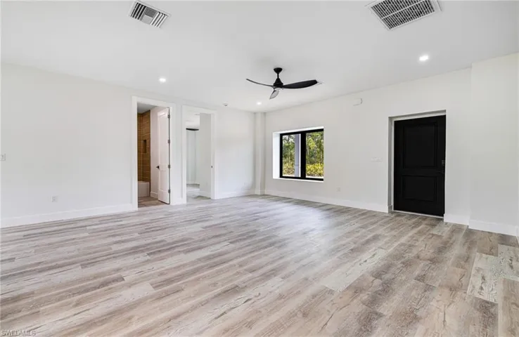 Unfurnished room featuring baseboards, visible vents, a ceiling fan, and light wood finished floors