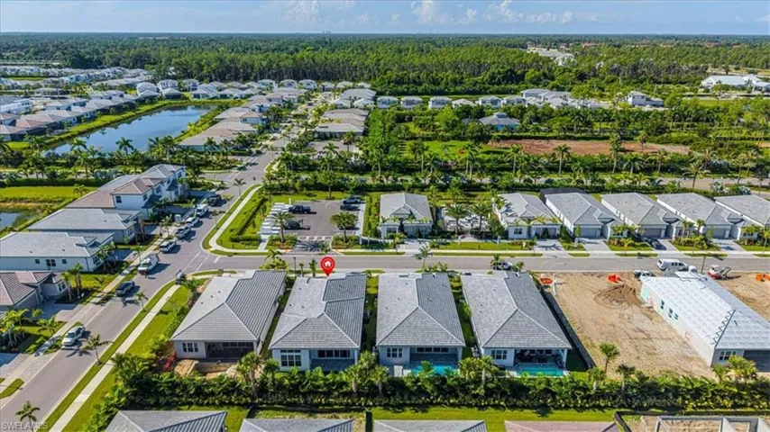 Aerial perspective showcasing a residential community with mature landscaping, multiple water features, paved roadways, and a consistent architectural style