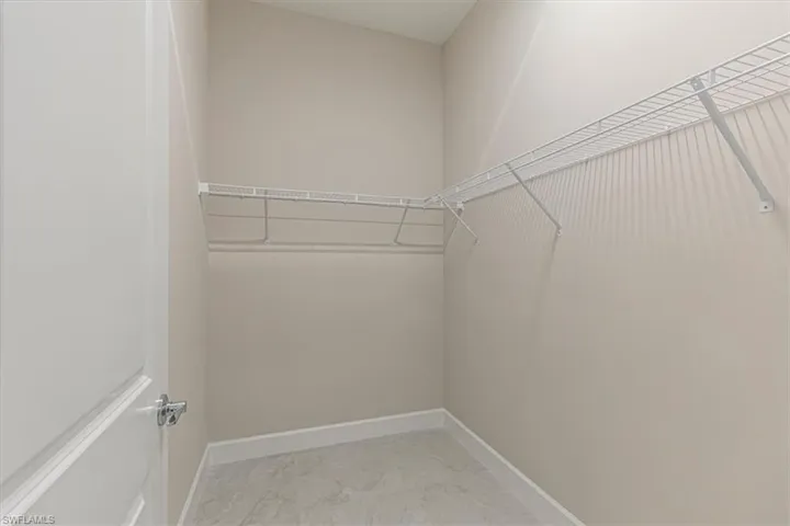 Walk-in closet with wire shelving and tile flooring