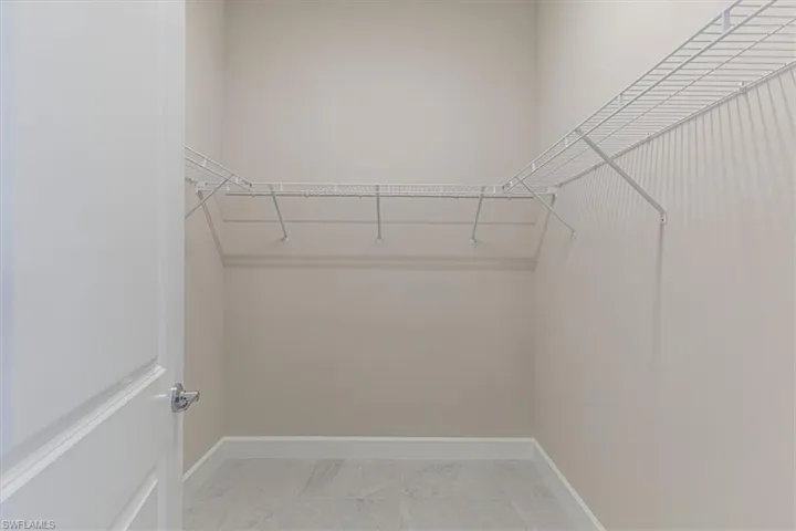 Walk-in closet featuring wire shelving, light-toned wall paint, and tile flooring