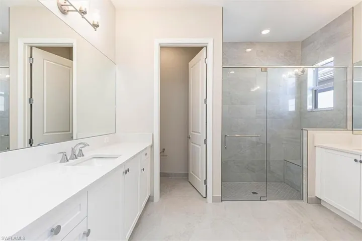 Dual vanities with white cabinetry and integrated sinks