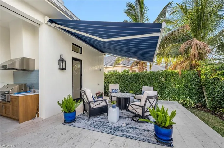 Extended outdoor sitting area with fire pit and retractable awning.  Also, you can see an outdoor shower...