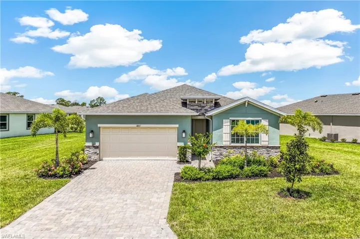 Contemporary exterior with a stone accent facade, a paved driveway, and mature landscaping