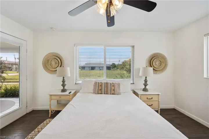 Bedroom with dark wood-style floors, baseboards, and a ceiling fan