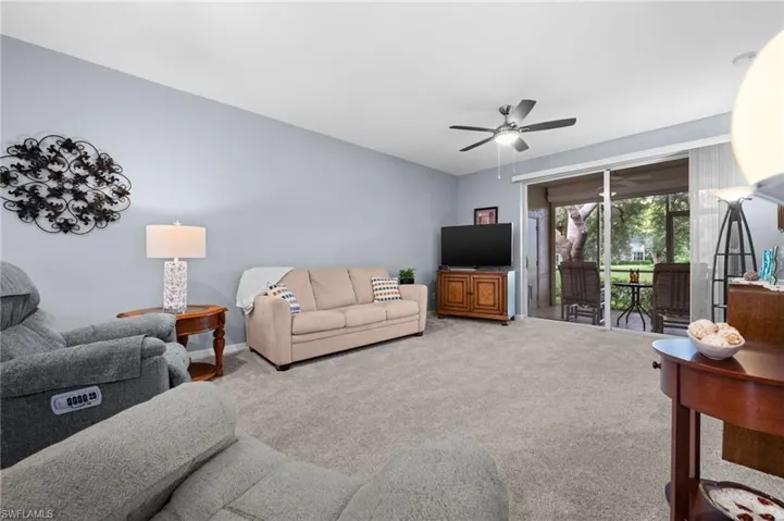 Recessed ceiling with a ceiling fan, light-toned wall paint, and light gray carpeting