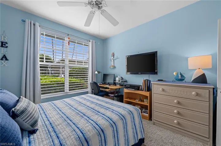 Recessed window with horizontal blinds, overhead ceiling fan, and carpeted flooring