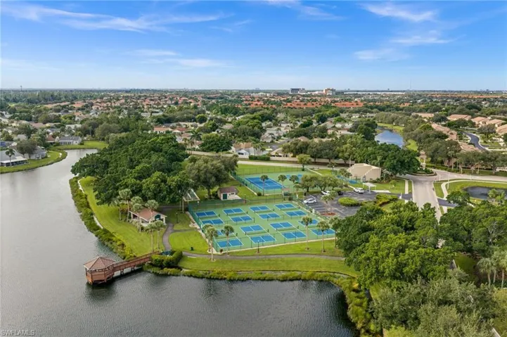 Community amenities featuring multiple tennis courts, a lake, and surrounding green spaces