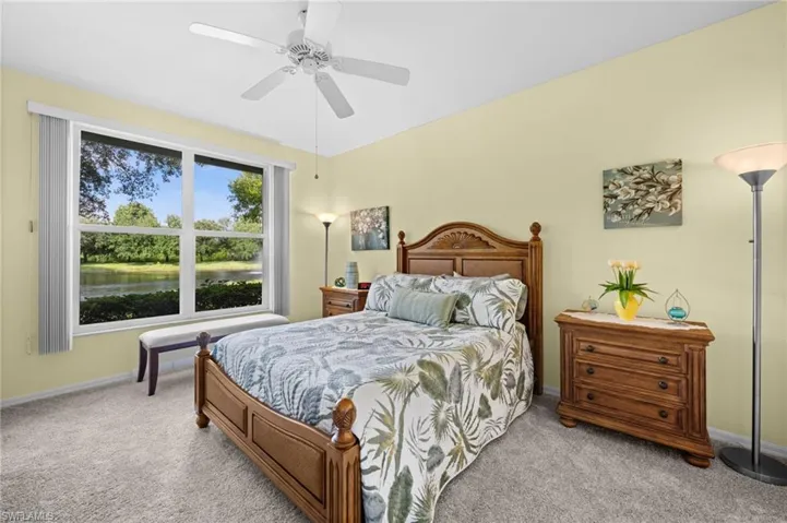 Primary Bedroom: Carpeted bedroom featuring a large window, ceiling fan.