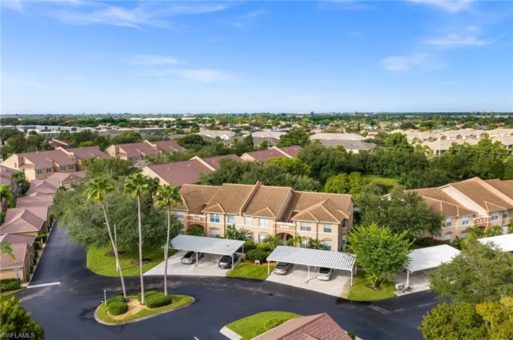 Aerial perspective highlighting a multi-unit property with a paved cul-de-sac and covered parking structures