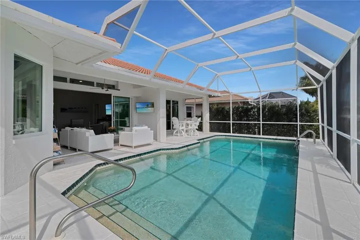 Dock area featuring boat lift, a water view, a yard, a residential view, and a sunroom