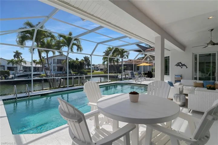 Dock area with a water view, a residential view, and a sunroom