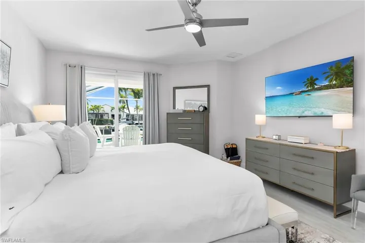 Bedroom with multiple closets, access to exterior, and ceiling fan