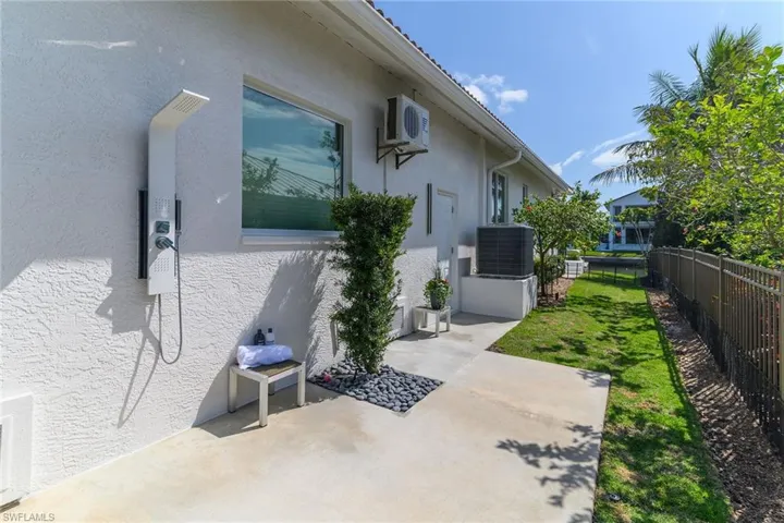 View of side of property featuring stucco siding and a cooling unit