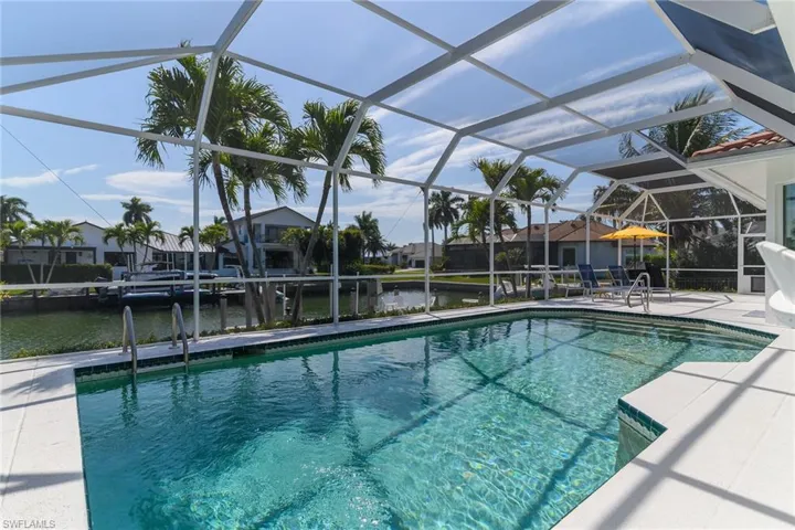 Dock with boat lift, a water view, and a residential view