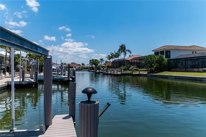 Dock area featuring a residential view, a lanai, boat lift, and a water view