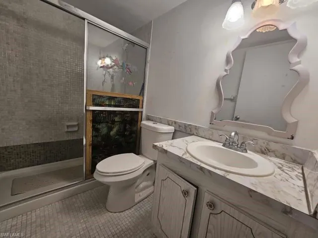 Bathroom with vanity, tile patterned flooring, and a stall shower