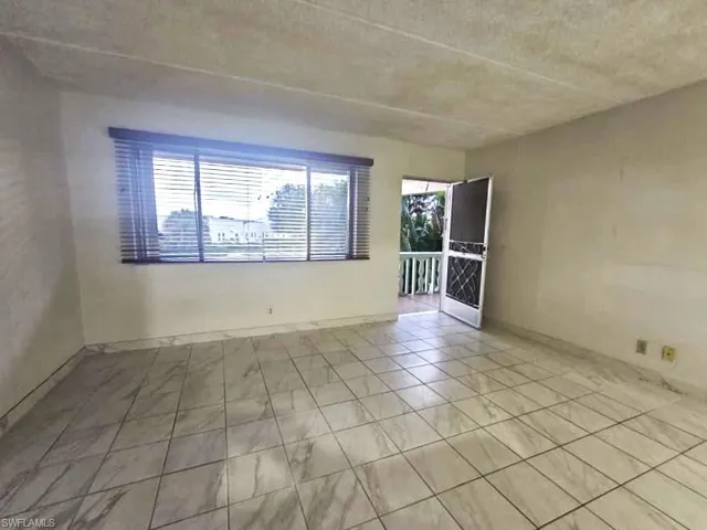 Empty room featuring healthy amount of natural light and a textured ceiling