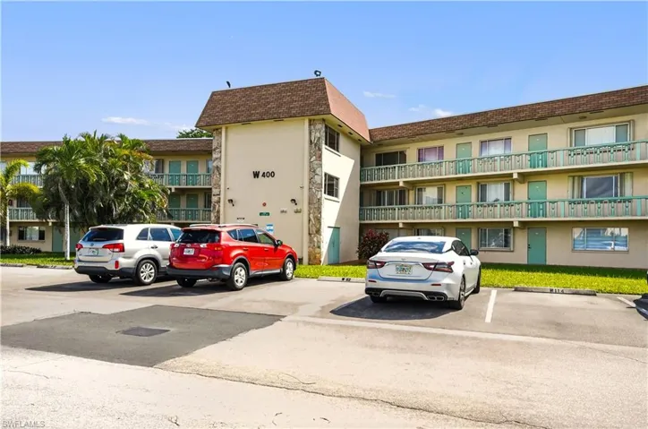 View of apartment building / complex featuring uncovered parking