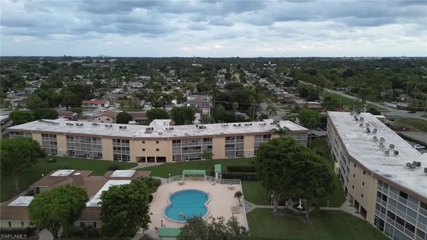Drone / aerial view of a pool area and apartment complex