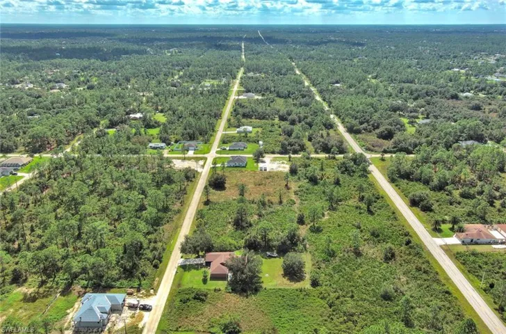 Aerial view of property and surrounding area featuring a heavily wooded area