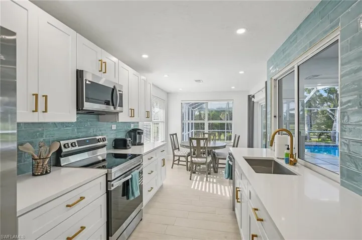 Kitchen featuring stainless steel appliances, white cabinets, recessed lighting, light wood-type flooring, and tasteful backsplash
