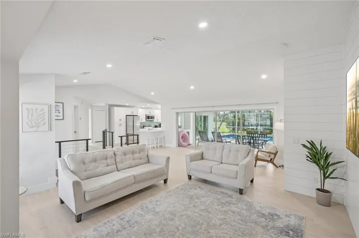 Living room featuring lofted ceiling, light wood-style flooring, and recessed lighting