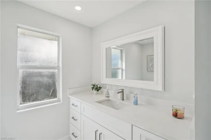Bathroom with healthy amount of natural light, vanity, and recessed lighting