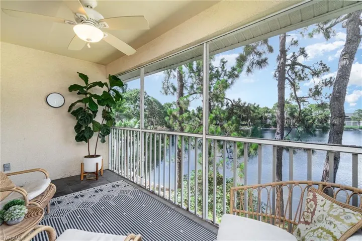 Sunroom / solarium with ceiling fan, a balcony, and a water view
