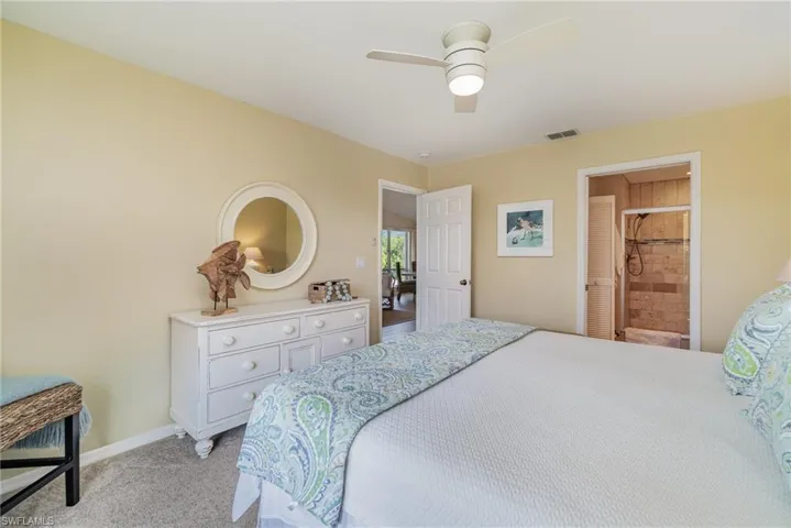 Bedroom featuring light carpet, ceiling fan, and connected bathroom
