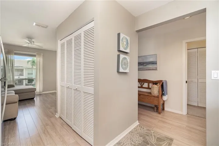 Corridor with light wood-type flooring and baseboards