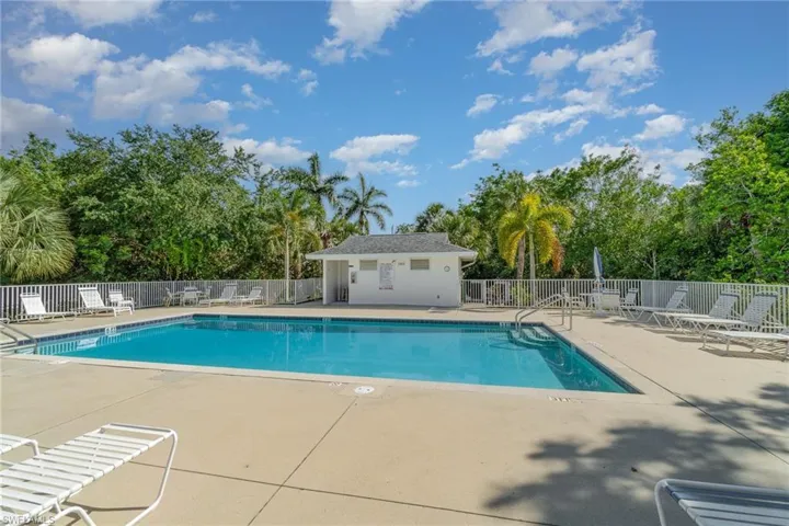 Community pool featuring a patio and view of wooded area