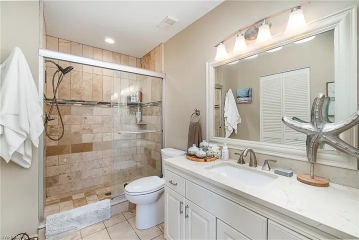 Bathroom featuring vanity, a stall shower, and light tile patterned flooring
