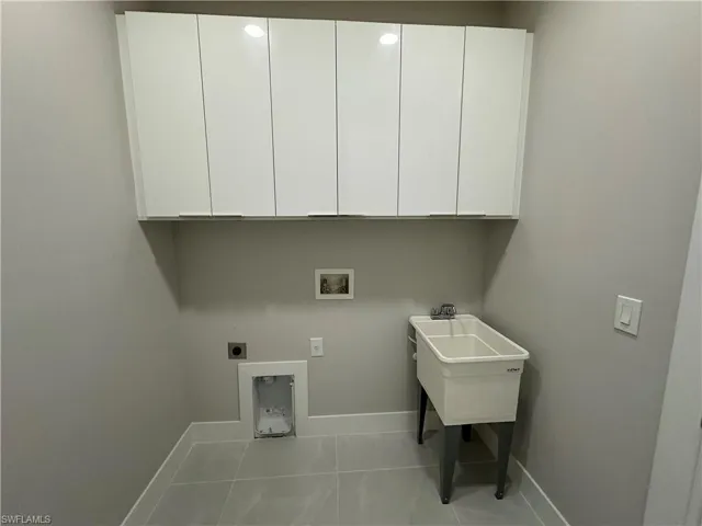 Washroom featuring cabinets, electric dryer hookup, washer hookup, and tile floors