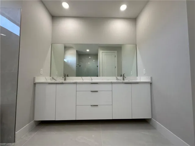 Bathroom featuring tile flooring and double sink vanity