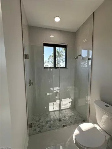 Bathroom with a shower with shower door and toilet