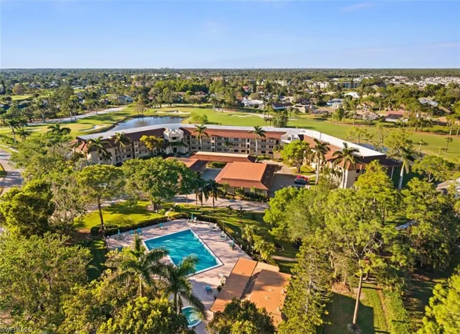 Aerial view of property's location featuring a local golf course and a nearby body of water