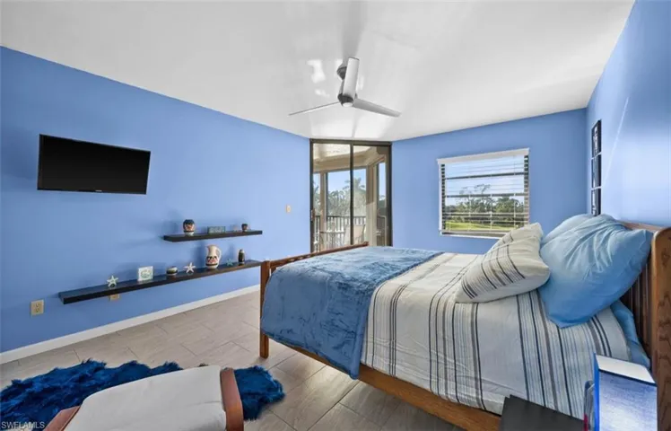 Bedroom with access to outside, wood finish floors, and a ceiling fan