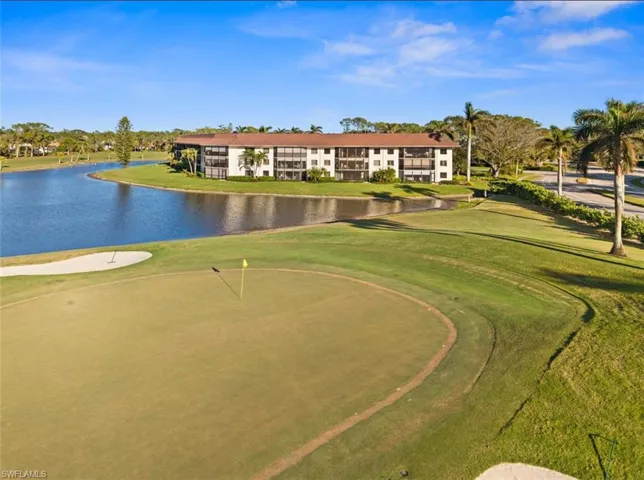 View of property's community featuring golf course view, a lawn, and a water view